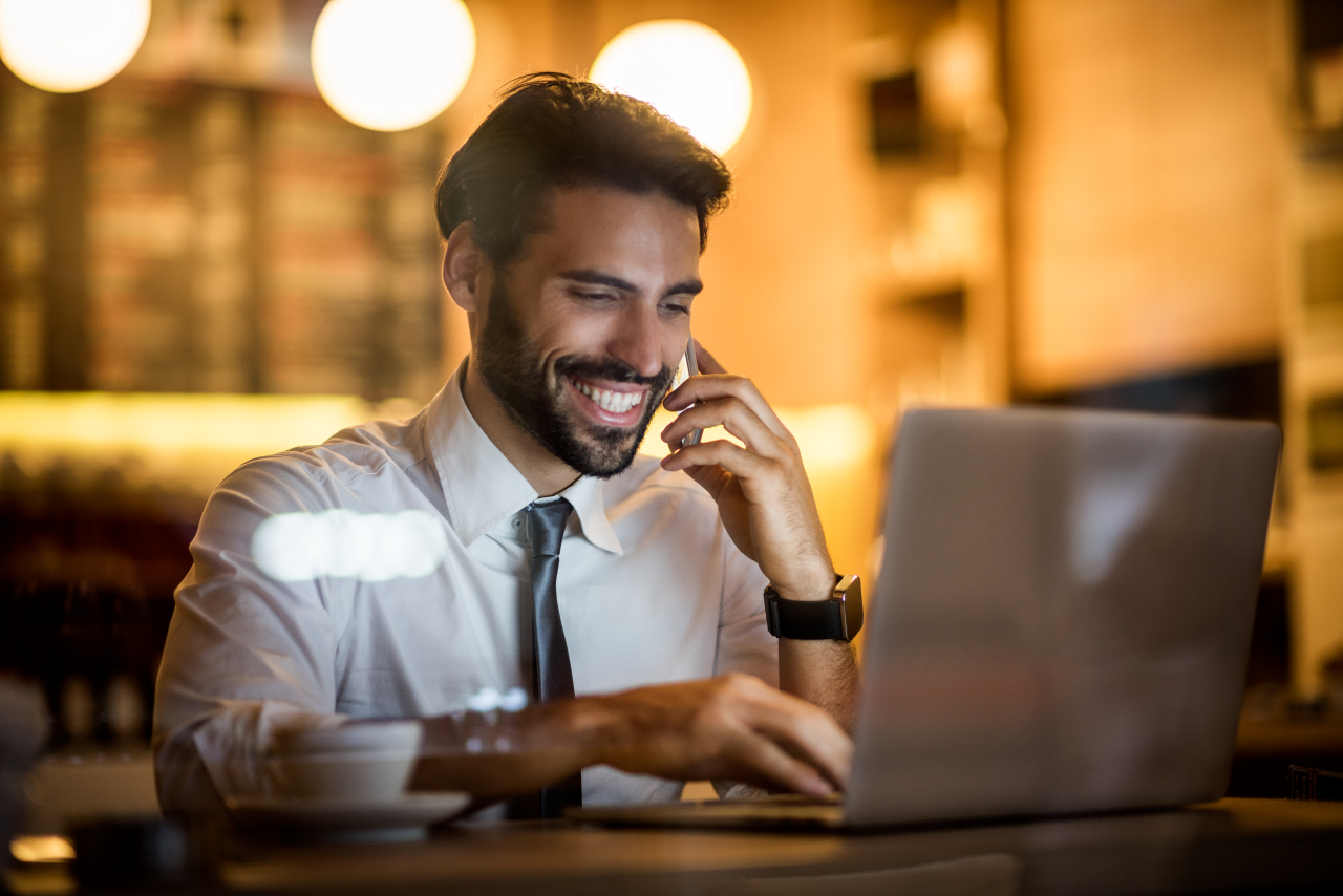 businessman with laptop making phone call