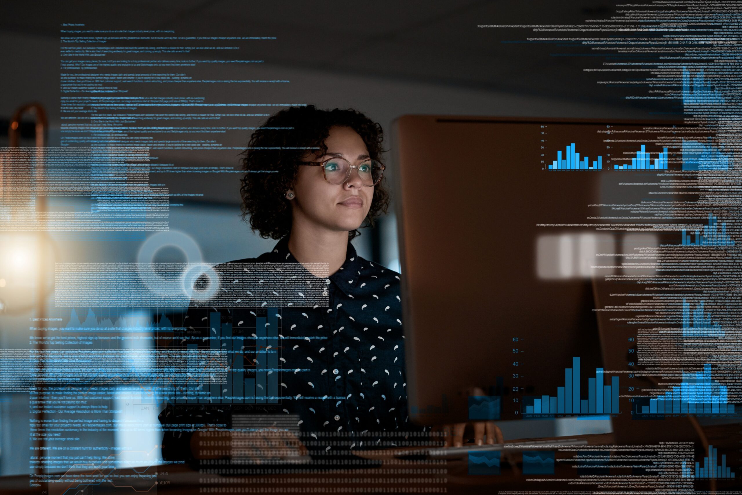 Woman in dark room looking at computer screen