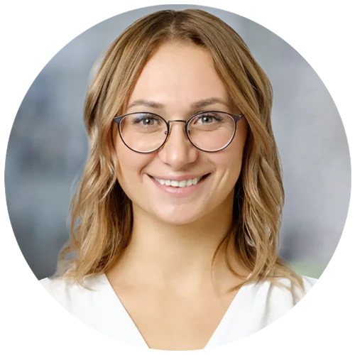 Photo portrait of young blonde woman with glasses looking at camera.