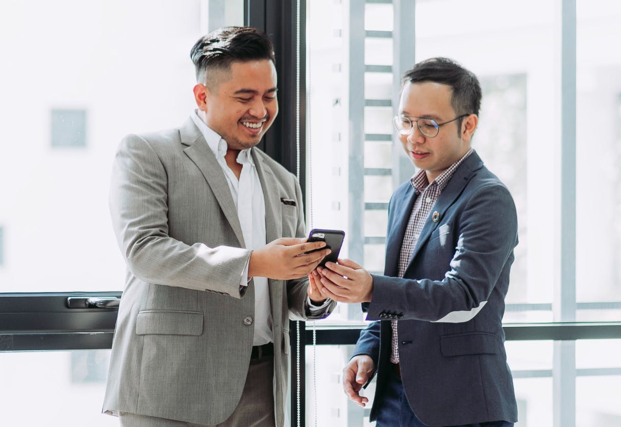 coworkers looking at phone together
