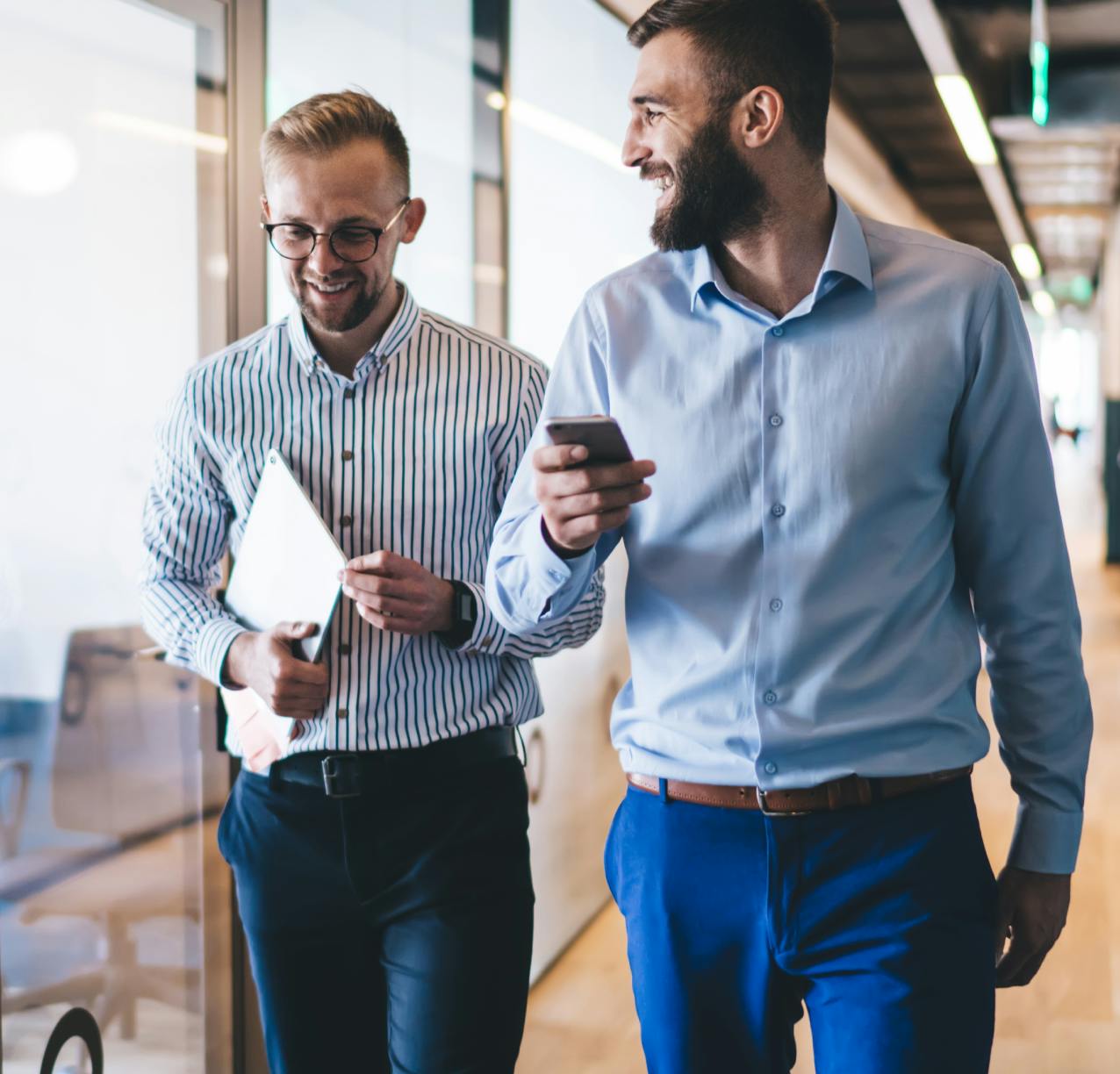 two men walking and talking in office
