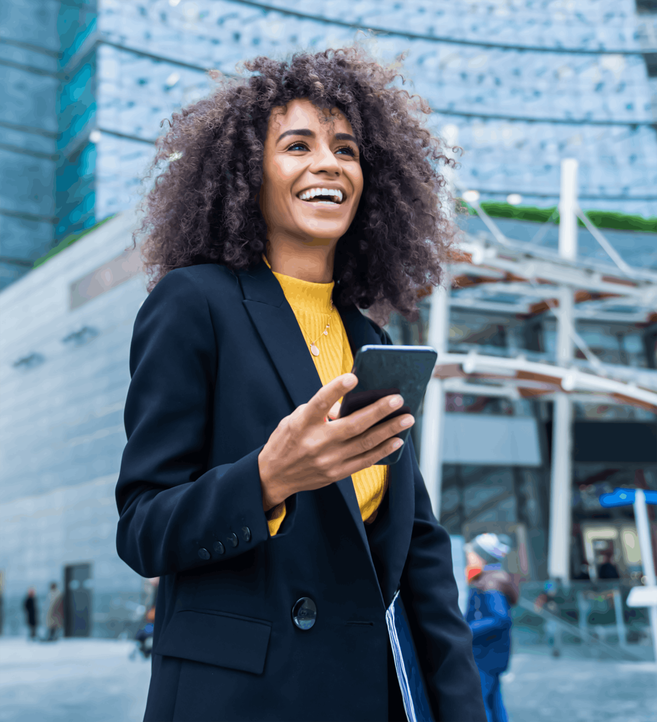 woman smiling outside while holding phone