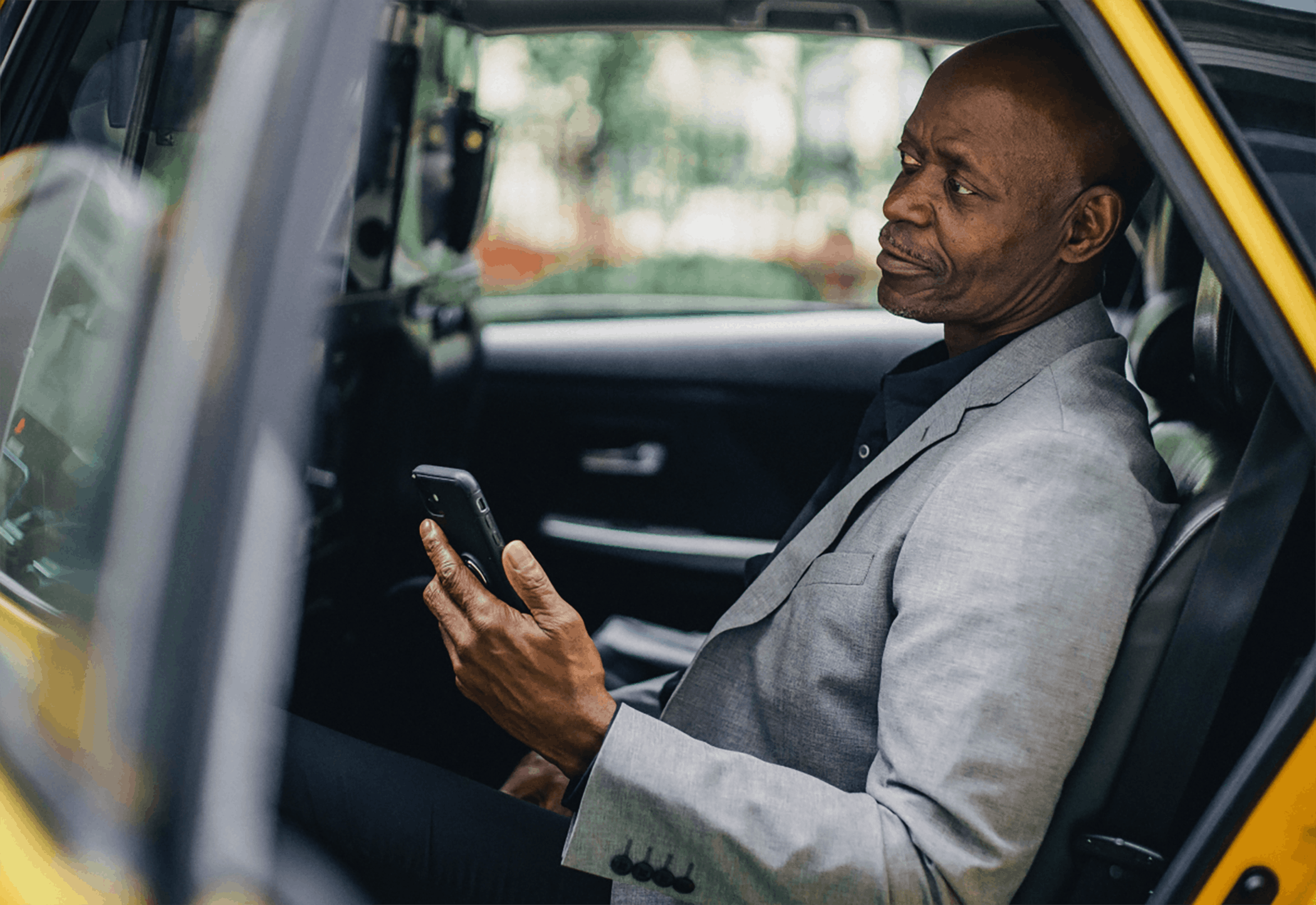 Man texting while traveling by cab
