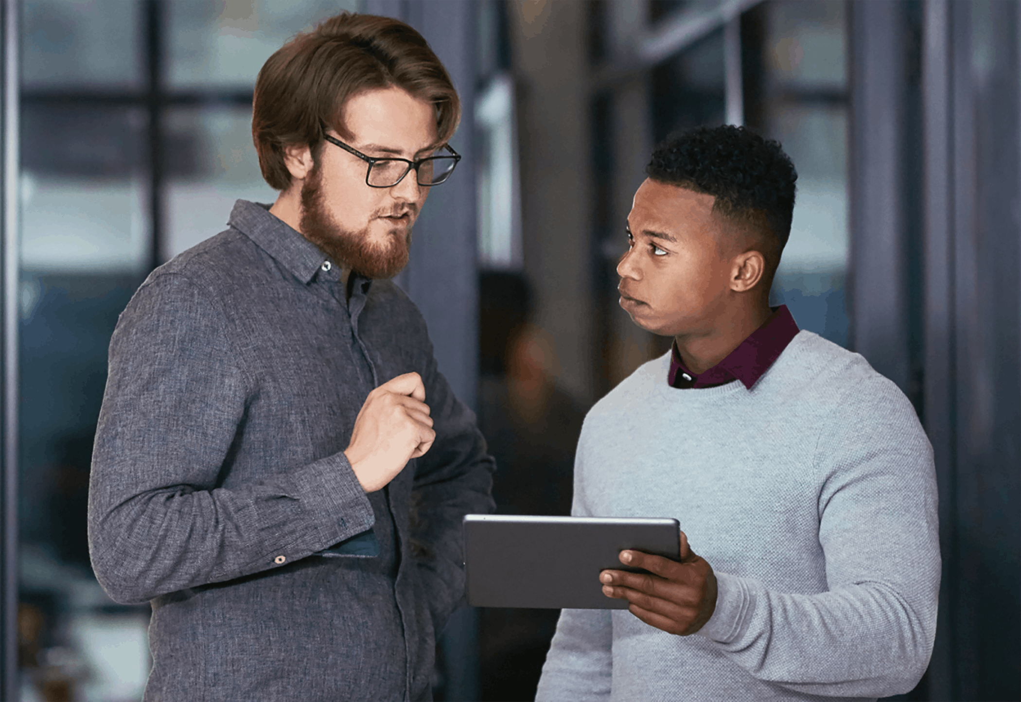 Two men looking at tablet standing meeting