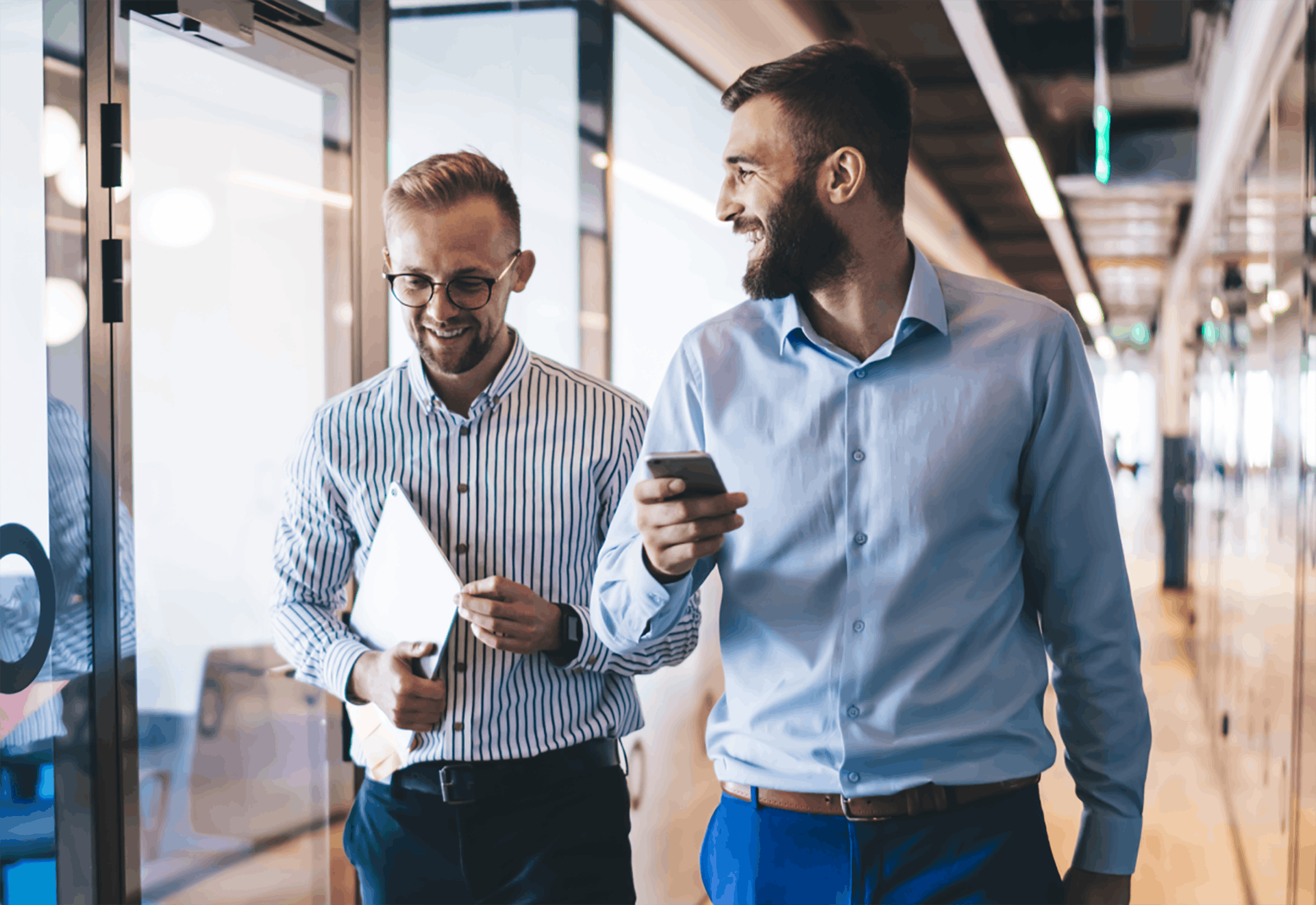 Two men walking in hallway chatting in office