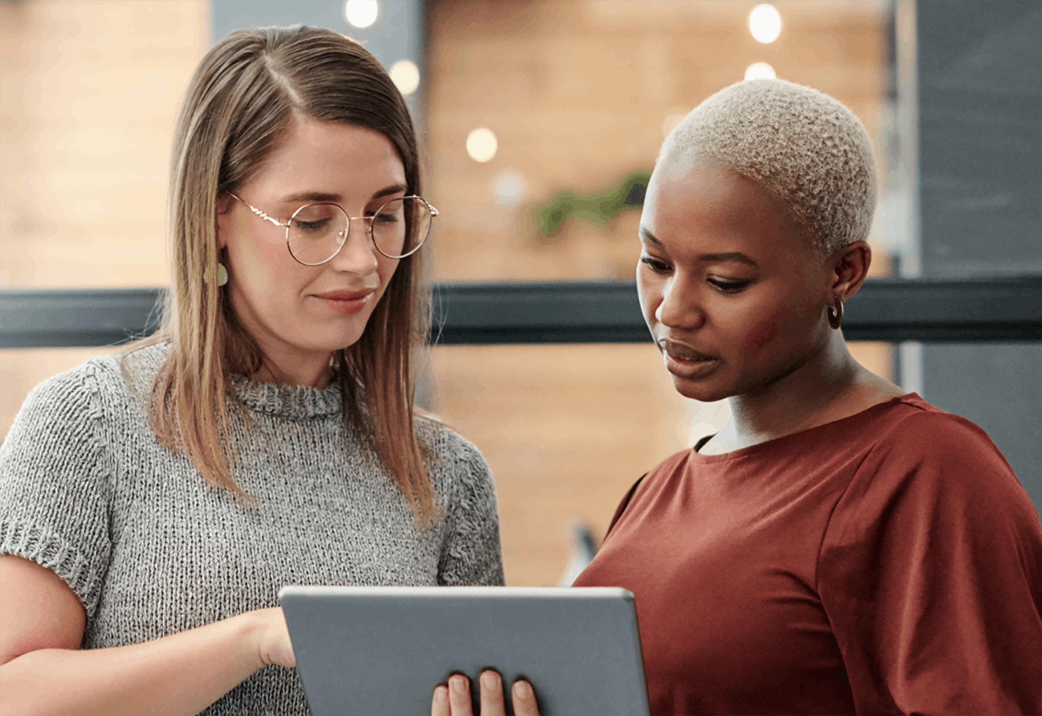 Two women meeting standing using tablet