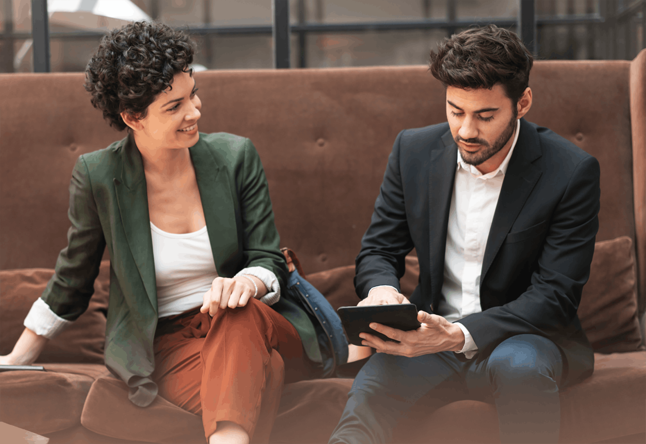 Woman and man sitting meeting on couch on tablet