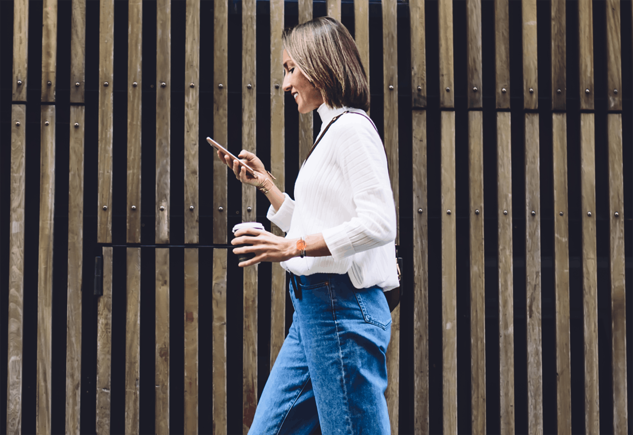 Woman walking and using phone outside