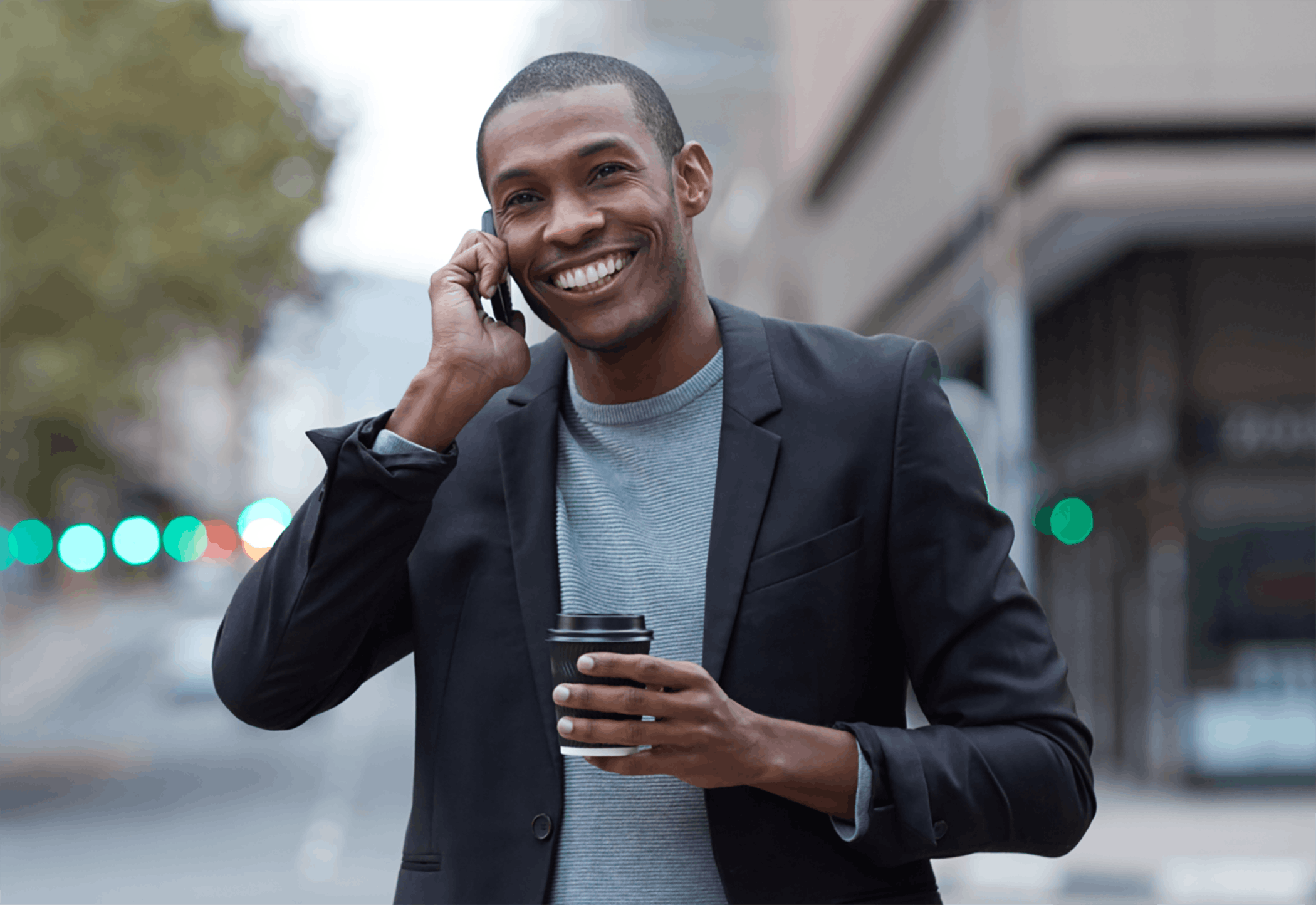 Man talking on phone while holding coffee