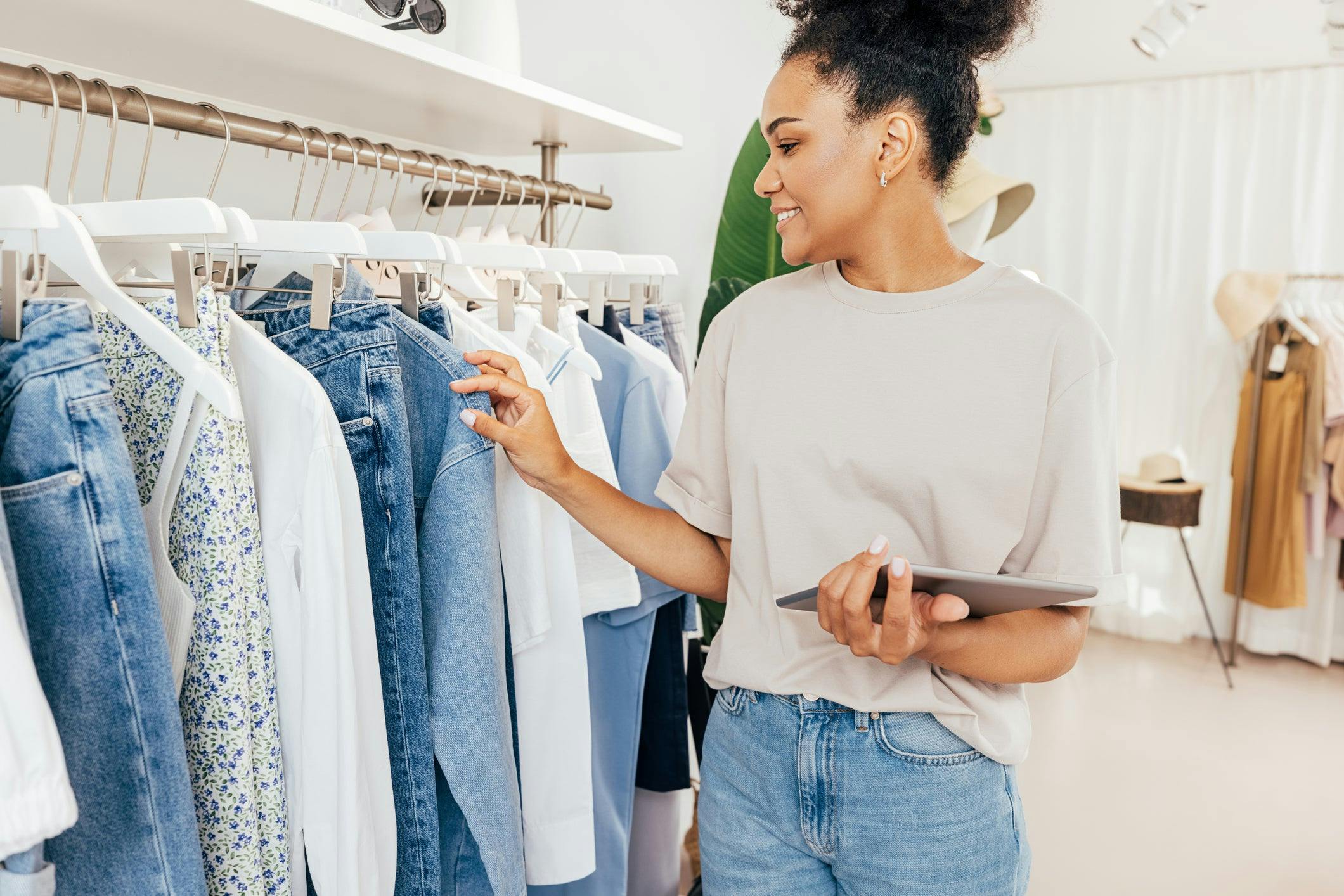 Woman holding a tablet and making an inventory in clothes store