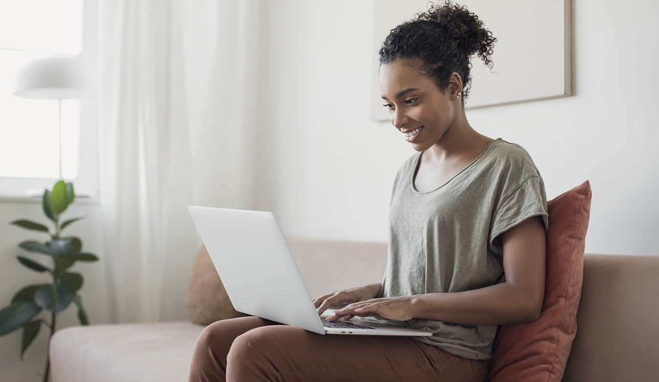 Woman on laptop sitting on couch