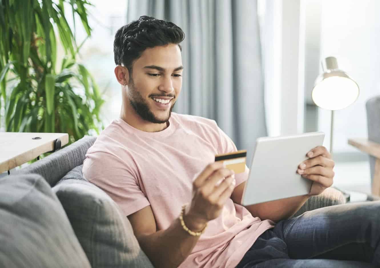 Man sitting on couch looking at card