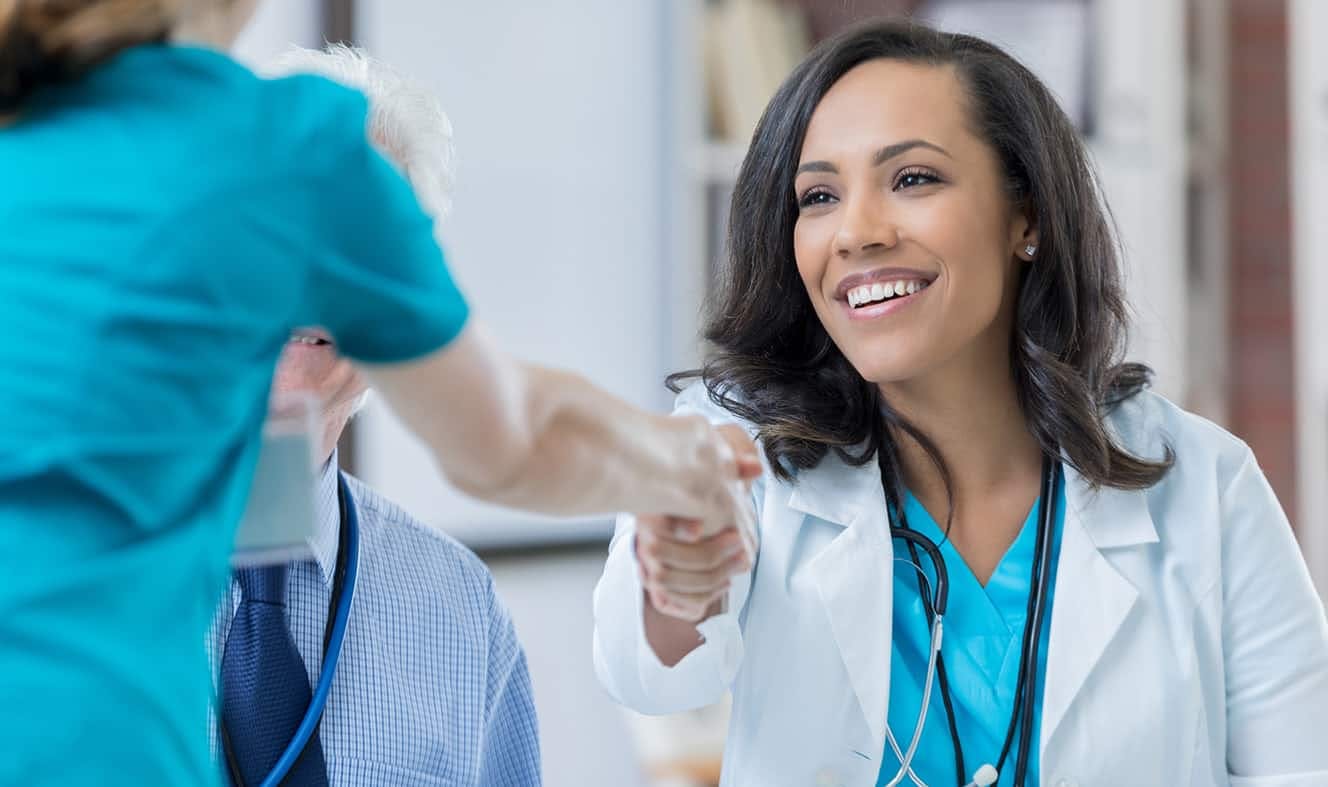 Woman doctor shaking hands with another person
