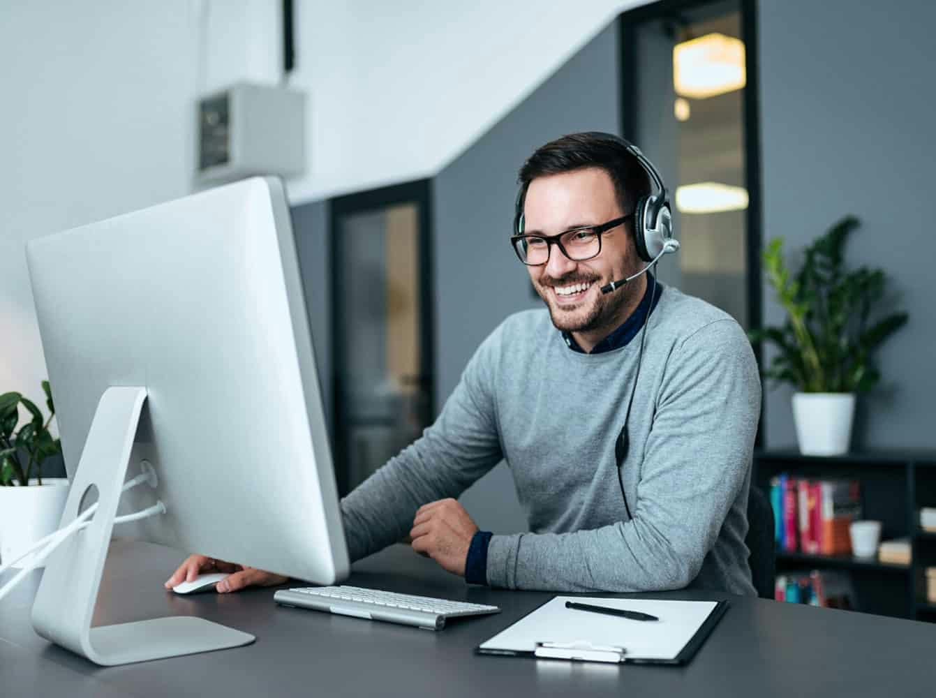 Man sitting at his desk with headset on