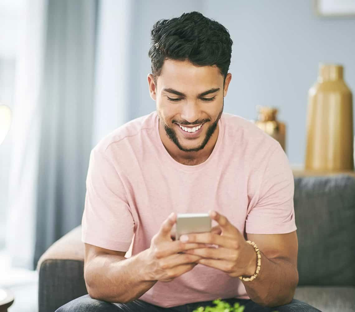 Man sitting on couch looking at phone