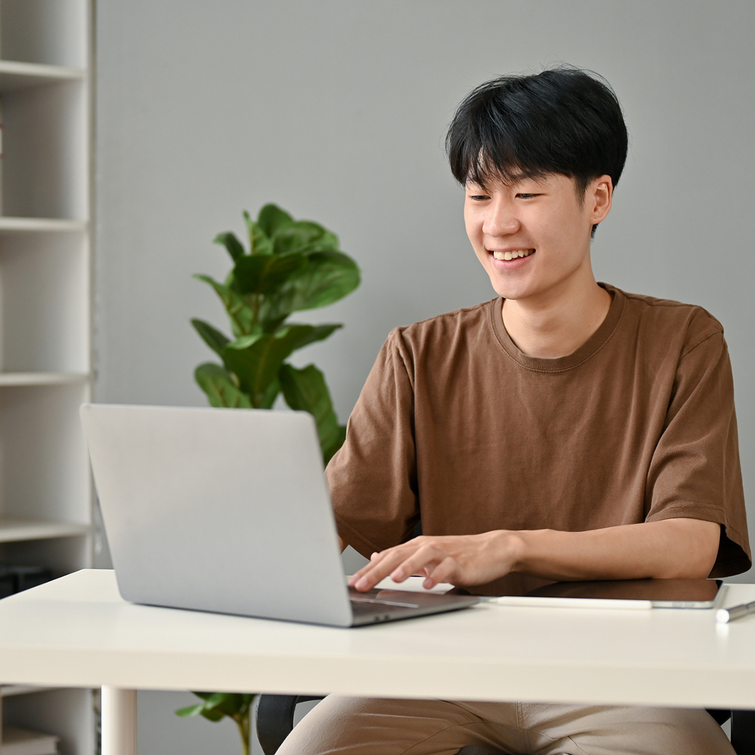 Man in brown shirt with a laptop