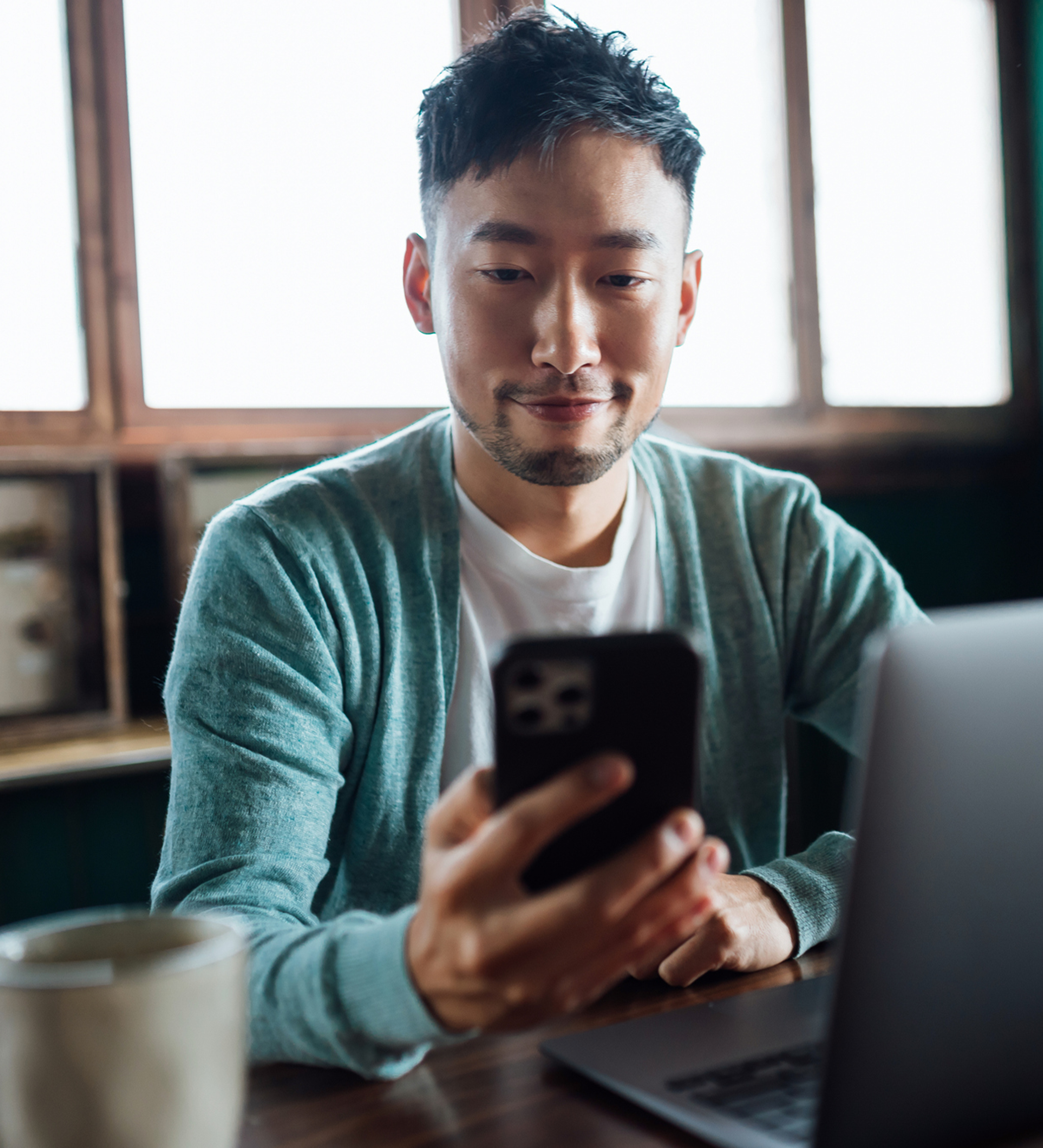 man phone laptop smiling