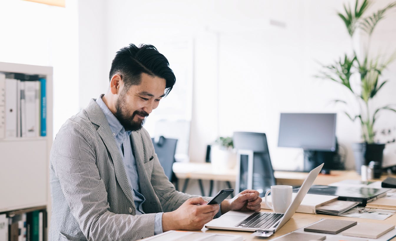 man using laptop and phone