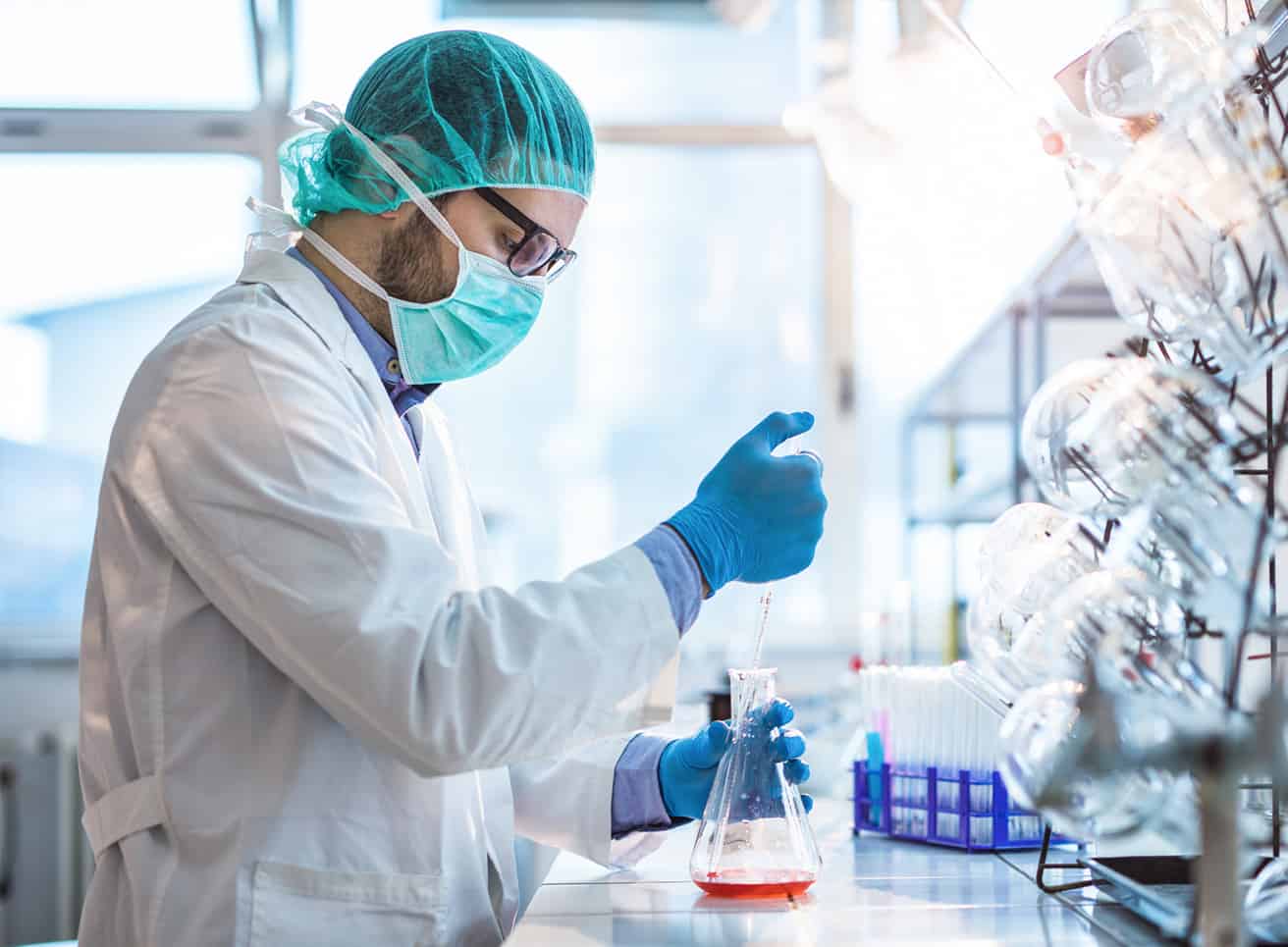 Man working in a lab filling test tubes