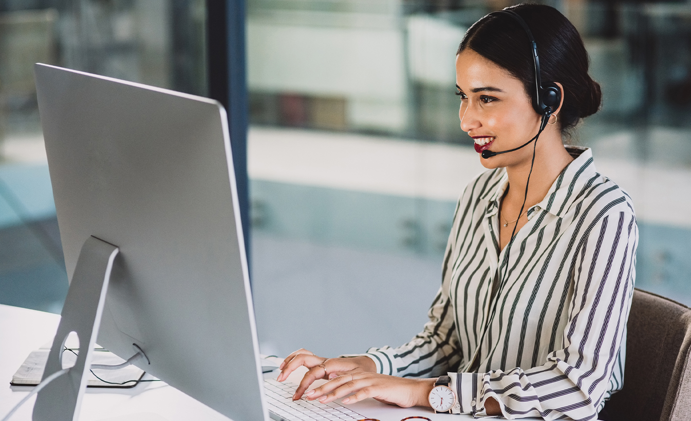 woman on desktop working and smiling